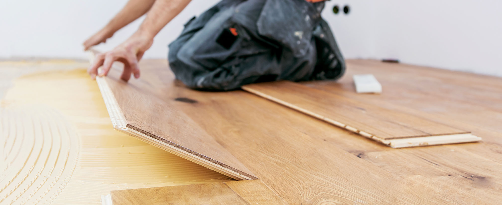 handwerker verleget parkett boden in einem modernen neubau haus